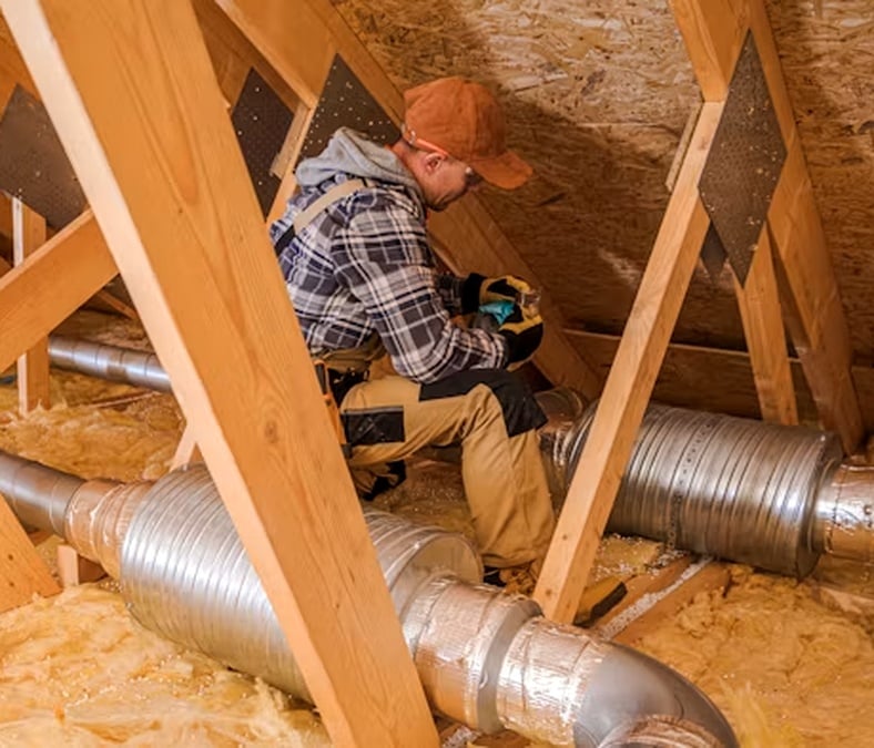 HVAC installer inspecting ductwork before installation