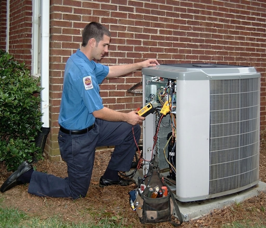 HVAC technician diagnosing an outdoor condenser for AC repair in Tennessee