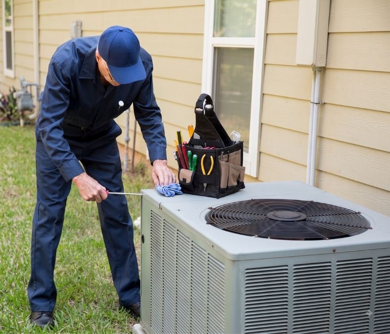 HVAC technician inspecting an aging air conditioner unit for signs of replacement in Smyrna TN