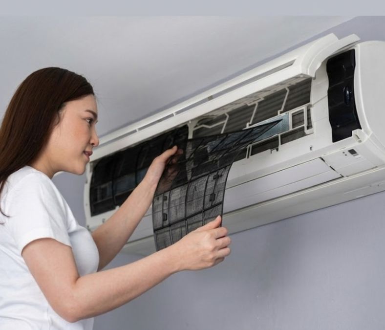 Homeowner checking an AC filter before scheduling air conditioning repair in MT Juliet TN