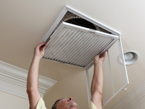Man changing an air filter in HVAC System.
