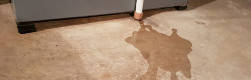 Water leak under furnace showing common HVAC condensation drain issue.